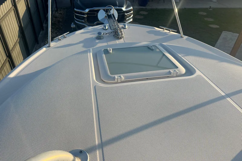 Slide: The Image of 2011 Wellcraft 232 Coastal boat deck with hatch, parked near a vehicle. - 14