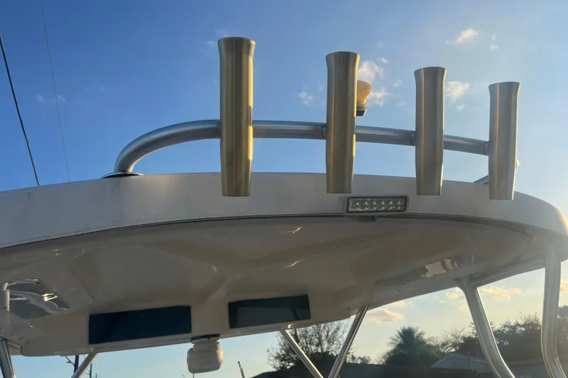 Slide: The Image of 2011 Wellcraft 232 Coastal boat top with rod holders against a clear sky. - 22
