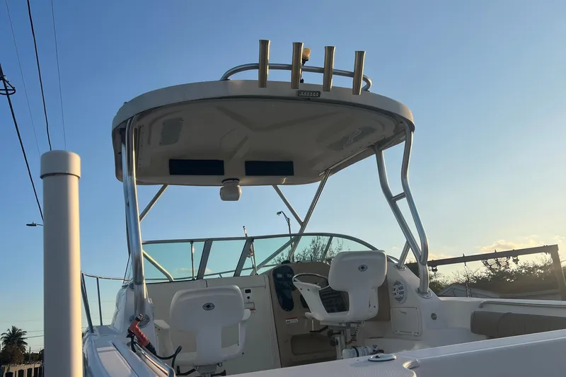 Slide: The Image of 2011 Wellcraft 232 Coastal boat interior with helm and seating under a clear sky. - 30