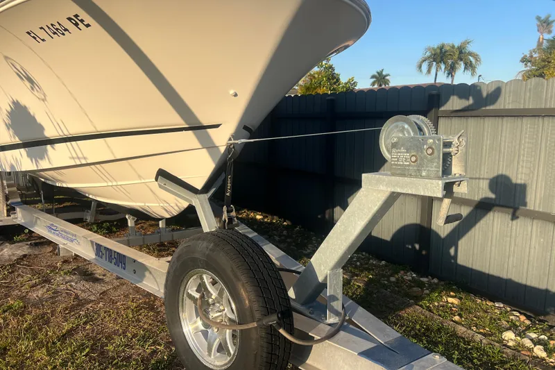 Slide: The Image of 2011 Wellcraft 232 Coastal boat on trailer, parked outdoors in sunny setting. - 36