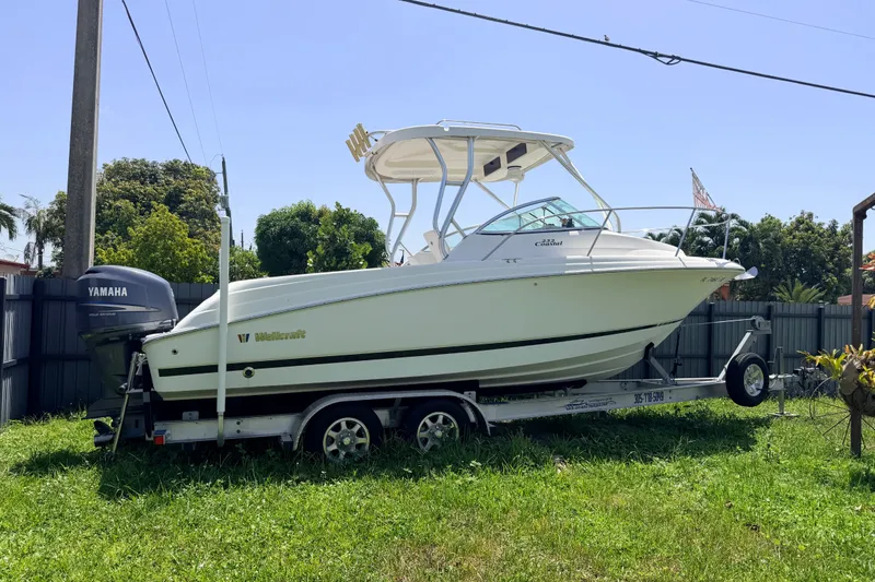 Slide: The Image of 2011 Wellcraft 232 Coastal boat on trailer with Yamaha outboard motor, parked on grass. - 34