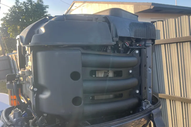 Slide: The Image of 2011 Wellcraft 232 Coastal outboard engine close-up in a sunny backyard setting. - 9