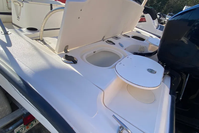Slide: The Image of 2004 Boston Whaler 220 Dauntless boat deck with storage compartments and motor. - 10