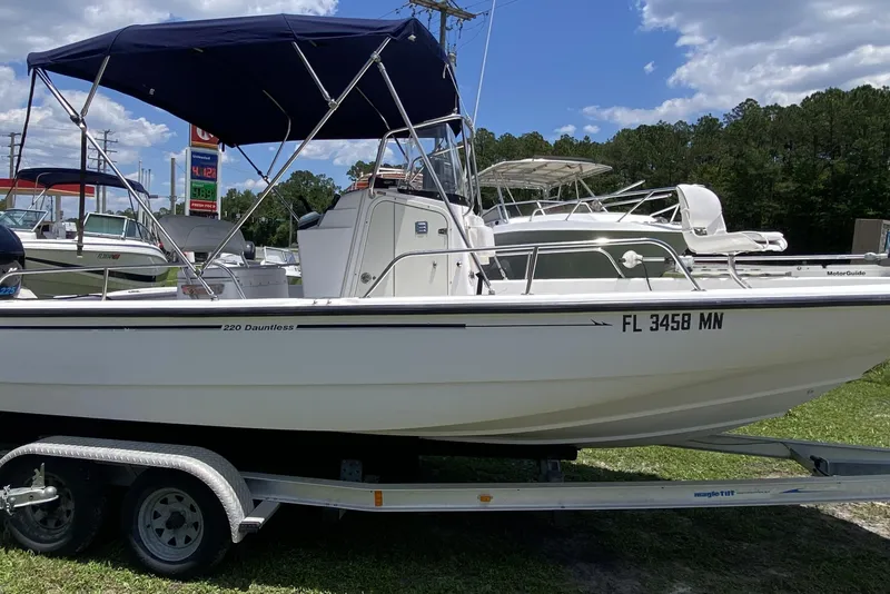 Slide: The Image of 2004 Boston Whaler 220 Dauntless boat on trailer, under blue sky. - 7
