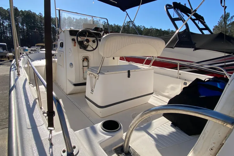 Slide: The Image of 2004 Boston Whaler 220 Dauntless boat deck with storage compartments and motor. - 8