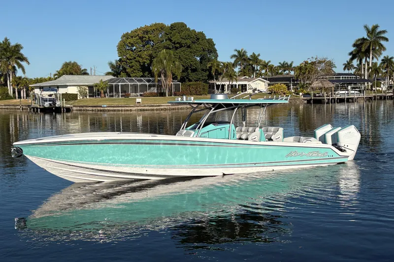The Image of 2024 Nor-Tech 390 Sport Center Console boat on calm water, surrounded by palm trees. - 0