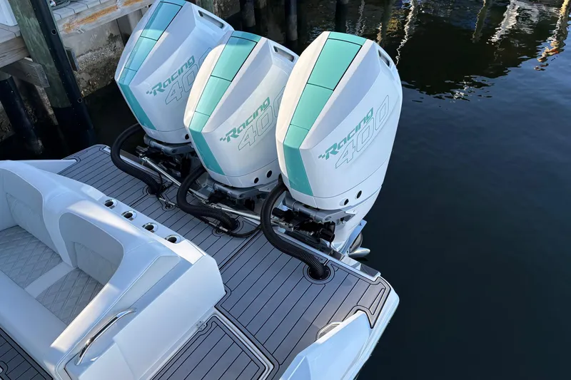 Slide: The Image of 2024 Nor-Tech 390 Sport Center Console with triple Racing 400 engines, docked on calm water. - 21