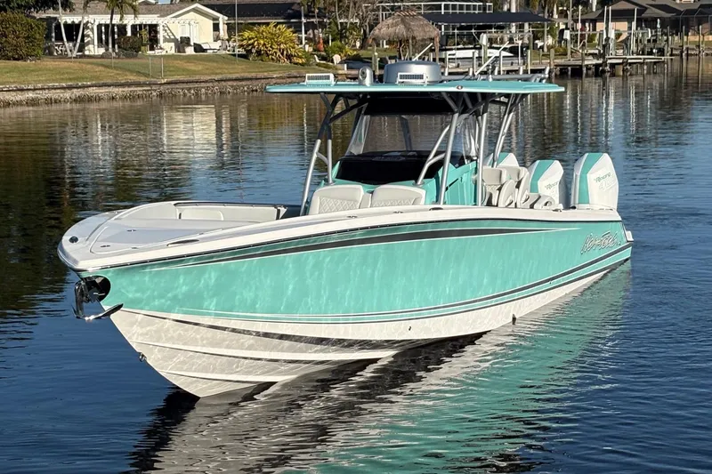 Slide: The Image of 2024 Nor-Tech 390 Sport Center Console boat on calm water, featuring a sleek turquoise design. - 3