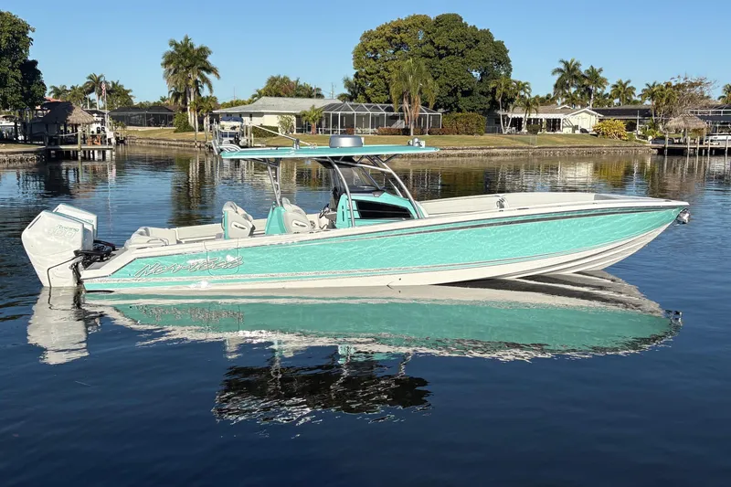Slide: The Image of 2024 Nor-Tech 390 Sport Center Console boat on calm water, surrounded by palm trees. - 4