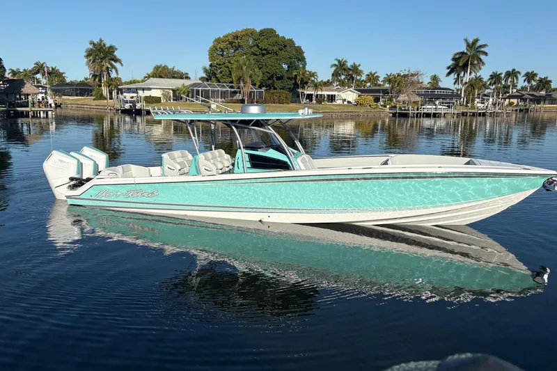 Slide: The Image of 2024 Nor-Tech 390 Sport Center Console boat on calm water, surrounded by palm trees. - 5