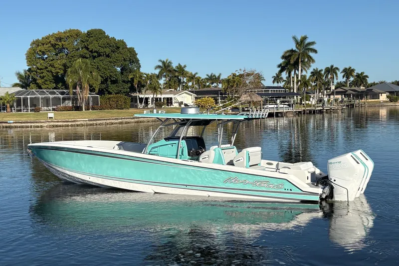 Slide: The Image of 2024 Nor-Tech 390 Sport Center Console boat on calm water, surrounded by palm trees. - 6