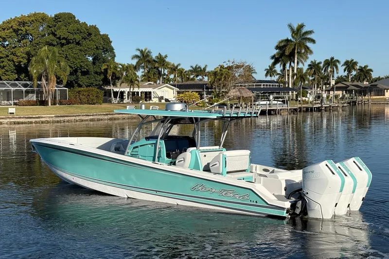 Slide: The Image of 2024 Nor-Tech 390 Sport Center Console boat on calm water, surrounded by palm trees. - 8