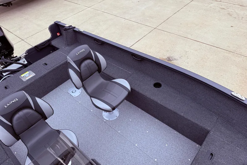 Slide: The Image of 2026 Lund 1650 Rebel XL SS boat interior with two gray seats on a textured floor. - 13