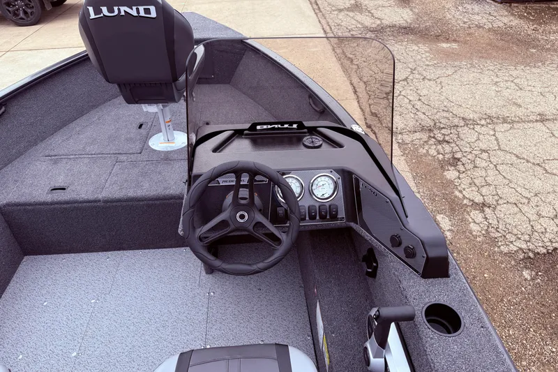 Slide: The Image of 2026 Lund 1650 Rebel XL SS boat interior with steering wheel and dashboard controls. - 14