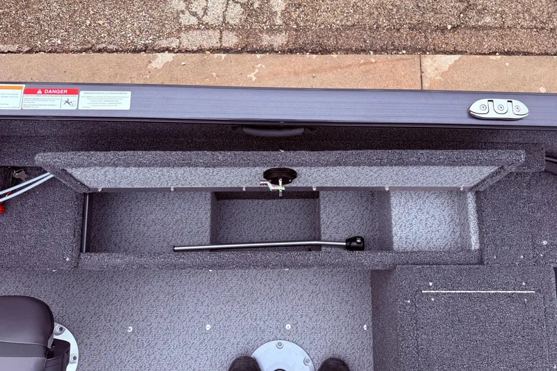 Slide: The Image of 2026 Lund 1650 Rebel XL SS boat interior storage compartment with safety warning label. - 16