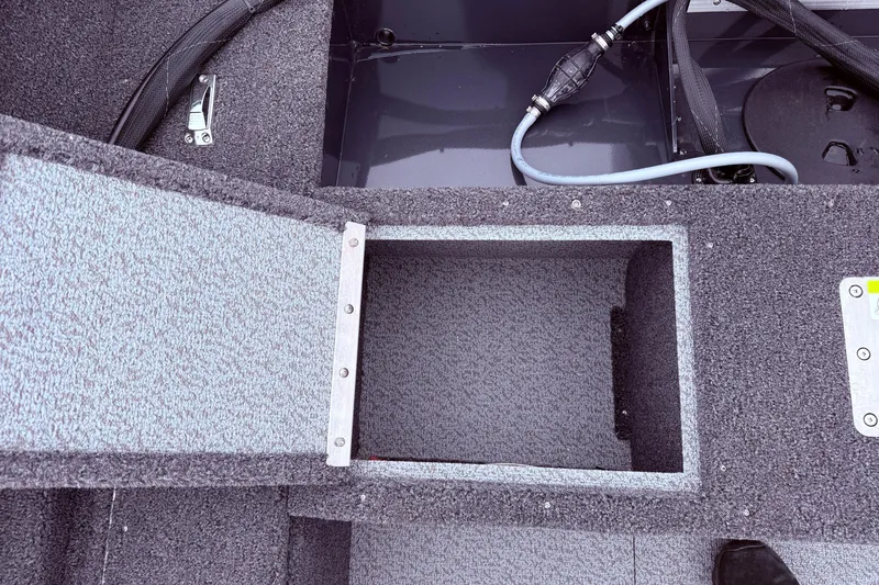 Slide: The Image of 2026 Lund 1650 Rebel XL SS boat interior storage compartment with carpeted finish. - 17