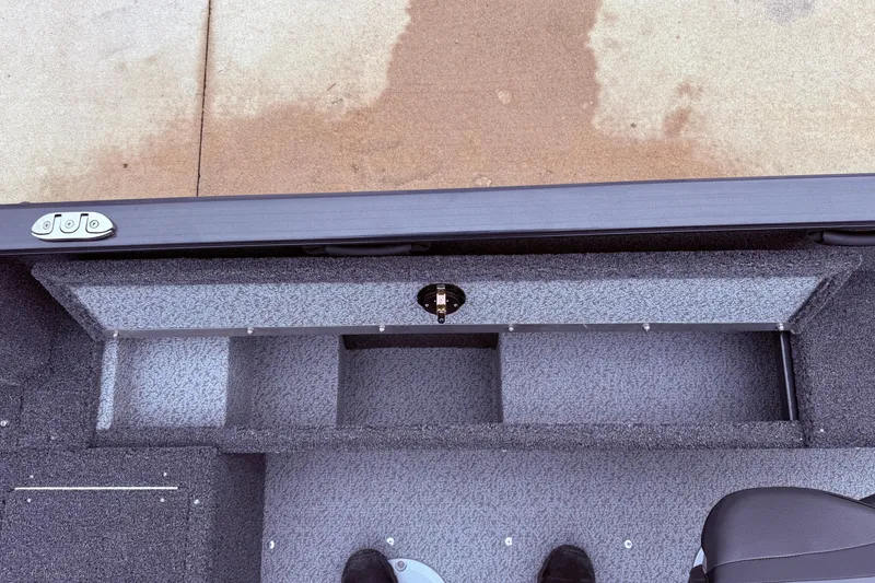 Slide: The Image of 2026 Lund 1650 Rebel XL SS boat interior storage compartment, gray carpeted finish. - 19