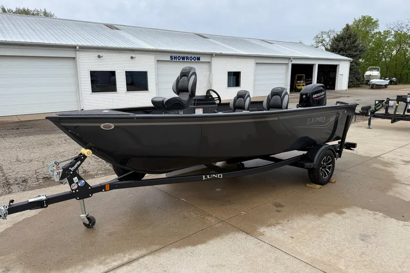 Slide: The Image of 2026 Lund 1650 Rebel XL SS boat on trailer outside showroom. - 2