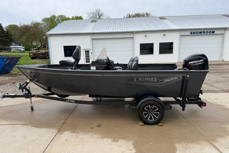 Slide: The Image of 2026 Lund 1650 Rebel XL SS boat on trailer outside showroom. - 3