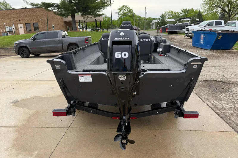 Slide: The Image of 2026 Lund 1650 Rebel XL SS boat with Mercury 60 engine, parked outdoors. - 5
