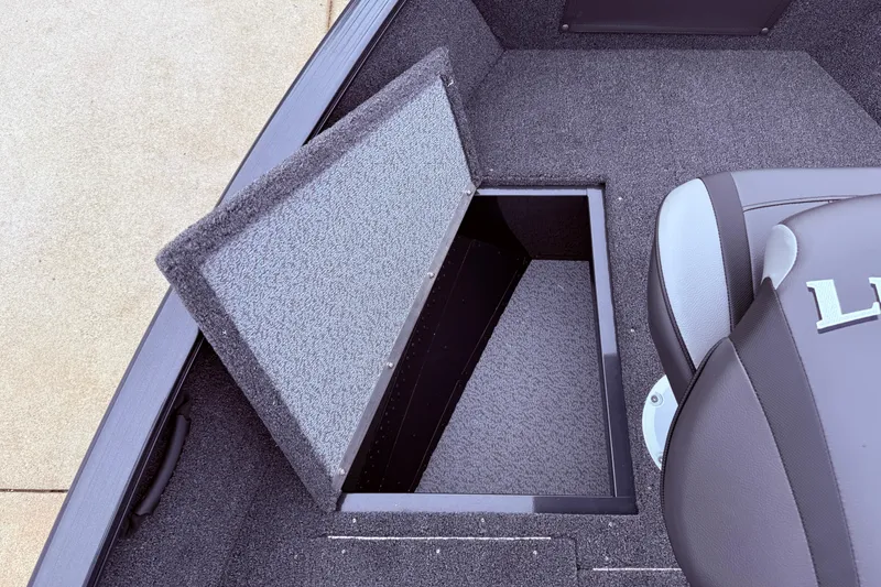 Slide: The Image of 2026 Lund 1650 Rebel XL SS boat interior with open storage compartment and seating. - 8