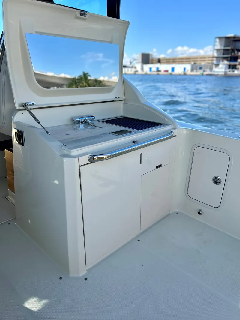 Slide: The Image of 2023 Chris-Craft 35 CALYPSO boat interior with sink and storage, docked by the water. - 10