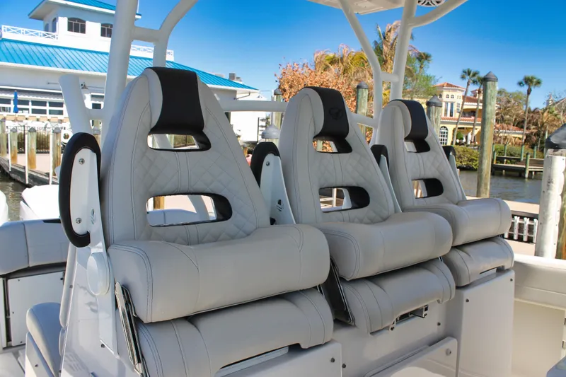 Slide: The Image of 2024 Sailfish 360 CC boat with luxurious seating, docked near waterfront homes. - 11