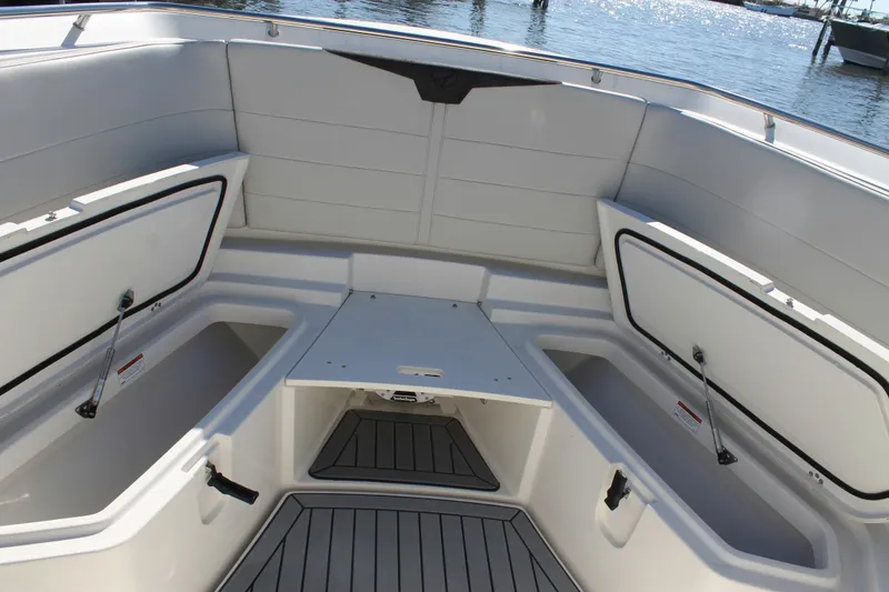 Slide: The Image of 2024 Sailfish 360 CC boat interior with open storage compartments, docked by the water. - 5