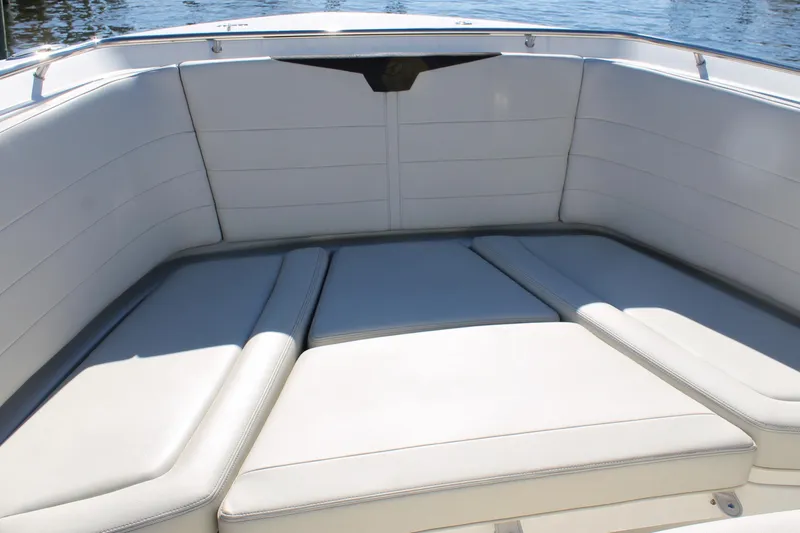 Slide: The Image of 2024 Sailfish 360 CC boat interior with cushioned seating, docked on water. - 6