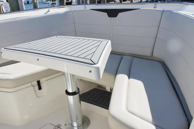 Slide: The Image of 2024 Sailfish 360 CC boat interior with cushioned seating and a sleek table. - 7