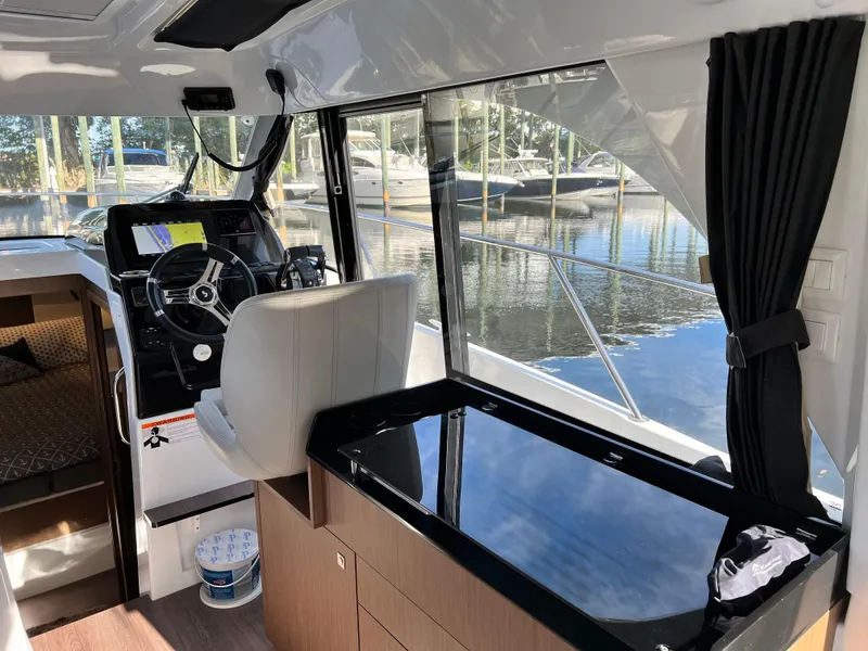Slide: The Image of Interior of 2021 Beneteau Antares 9 boat with helm station and seating. - 10
