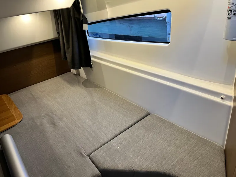 Slide: The Image of Interior cabin of 2021 Beneteau Antares 9 with grey cushions and window. - 16