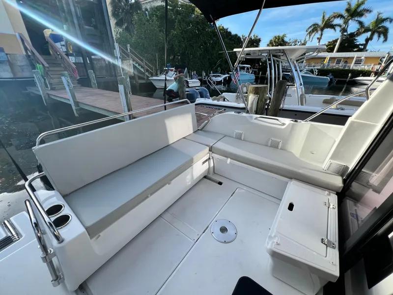 Slide: The Image of 2021 Beneteau Antares 9 boat interior with white seating and dock view. - 17