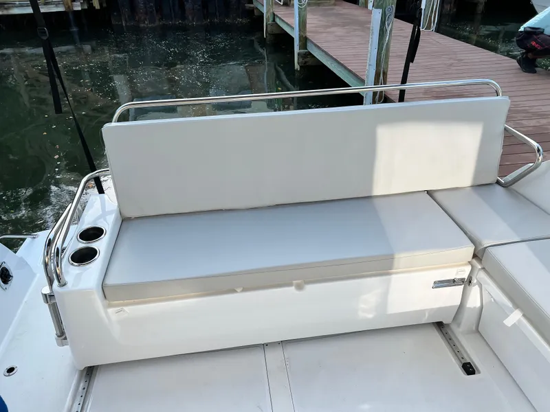 Slide: The Image of Beneteau Antares 9 2021 boat seating area with cup holders and dock in background. - 18