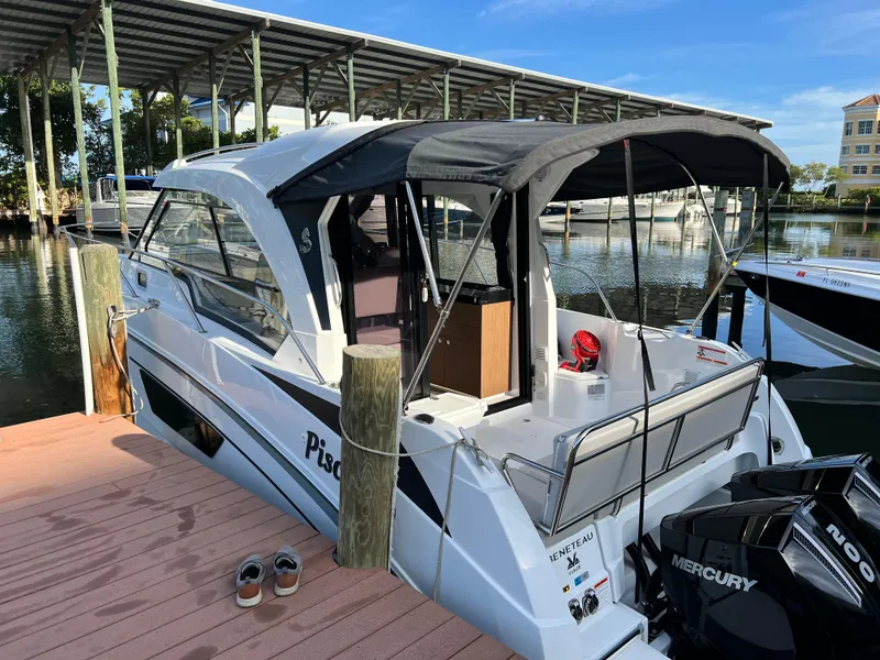 Slide: The Image of 2021 Beneteau Antares 9 docked, rear view with Mercury outboard motor. - 2