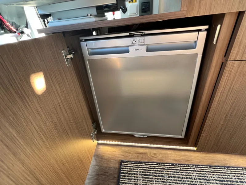 Slide: The Image of Beneteau Antares 9 2021 model interior, featuring a built-in Dometic refrigerator. - 22