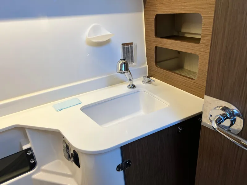 Slide: The Image of Modern bathroom sink in 2021 Beneteau Antares 9 boat, featuring sleek design and storage shelves. - 25