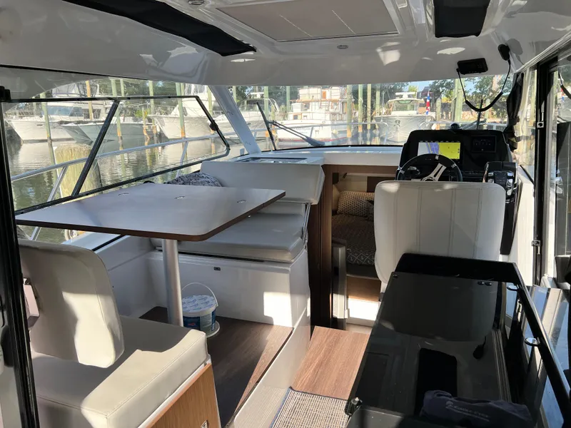 Slide: The Image of Interior of 2021 Beneteau Antares 9 boat with seating, table, and helm station. - 6