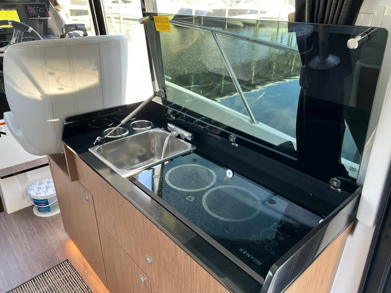 Slide: The Image of Modern kitchen area in a 2021 Beneteau Antares 9 boat with sink and stove. - 9