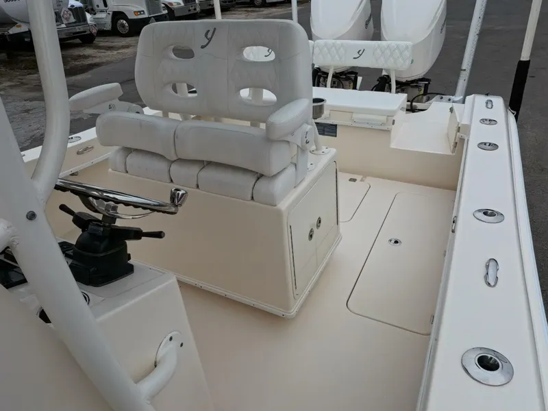 Slide: The Image of 2019 Young Boats 27 model, featuring spacious deck and cushioned seating on calm waters. - 21