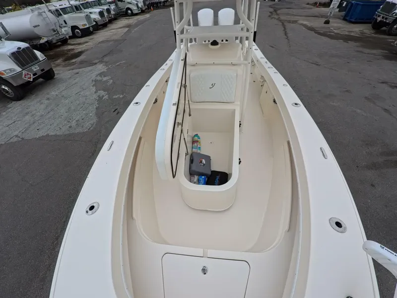 Slide: The Image of 2019 Young Boats 27 with white cushioned seating and armrests on a calm water backdrop. - 7