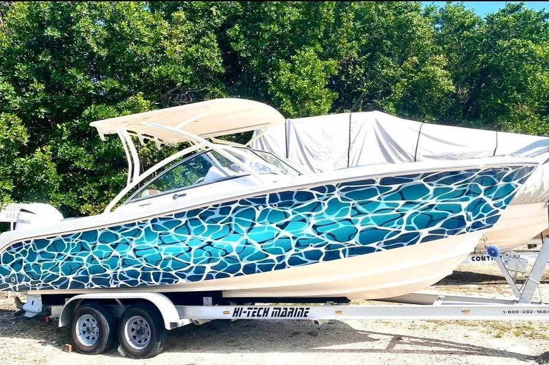 The Image of 2016 Edgewater 205CX Crossover boat with vibrant blue mosaic design on trailer. - 1