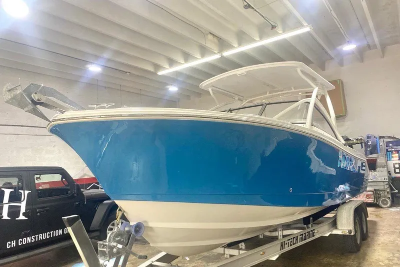 Slide: The Image of 2016 Edgewater 205CX Crossover boat in a garage, blue hull, on a trailer. - 20