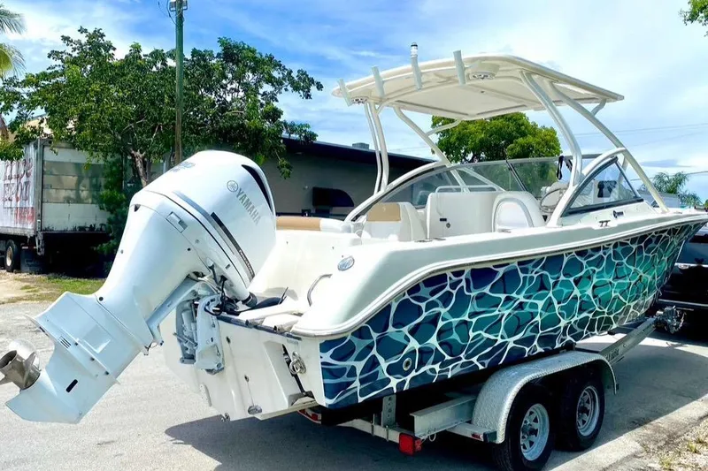 Slide: The Image of 2016 Edgewater 205CX Crossover boat with vibrant blue pattern on trailer. - 9