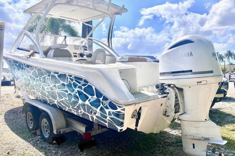 Slide: The Image of 2016 Edgewater 205CX Crossover boat with Yamaha engine, vibrant blue wave design. - 10