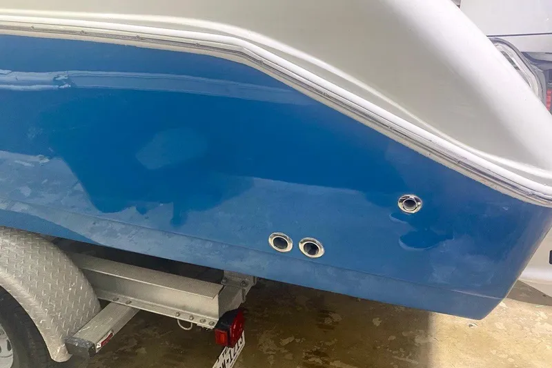 Slide: The Image of 2016 Edgewater 205CX Crossover boat, blue hull, on trailer, close-up view. - 16