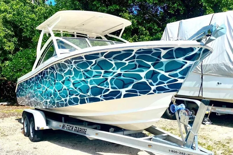 Slide: The Image of 2016 Edgewater 205CX Crossover boat with blue wave pattern on trailer. - 3