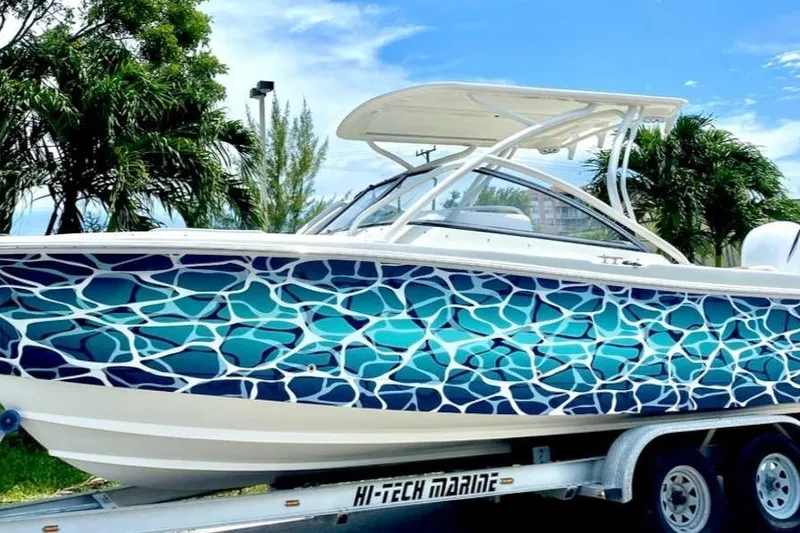 Slide: The Image of 2016 Edgewater 205CX Crossover boat with vibrant blue wave design on trailer. - 7