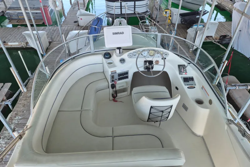 Slide: The Image of 2007 Bayliner Discovery 288 boat interior with helm, seating, and controls at dock. - 12