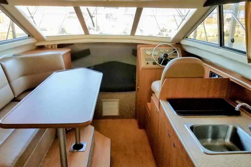 Slide: The Image of 2007 Bayliner Discovery 288 interior with helm, dining area, and kitchenette. - 15